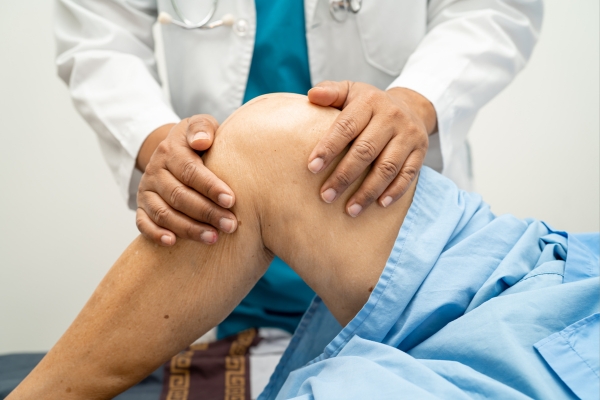 Pain doctor examining knee to show why pain management is important.